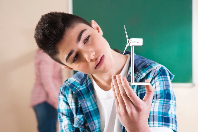 Student holding wind turbine model.