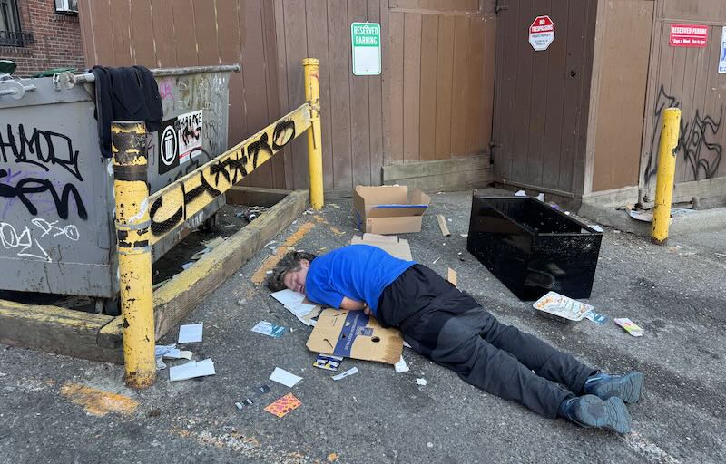 Human passed out next to dumpster.